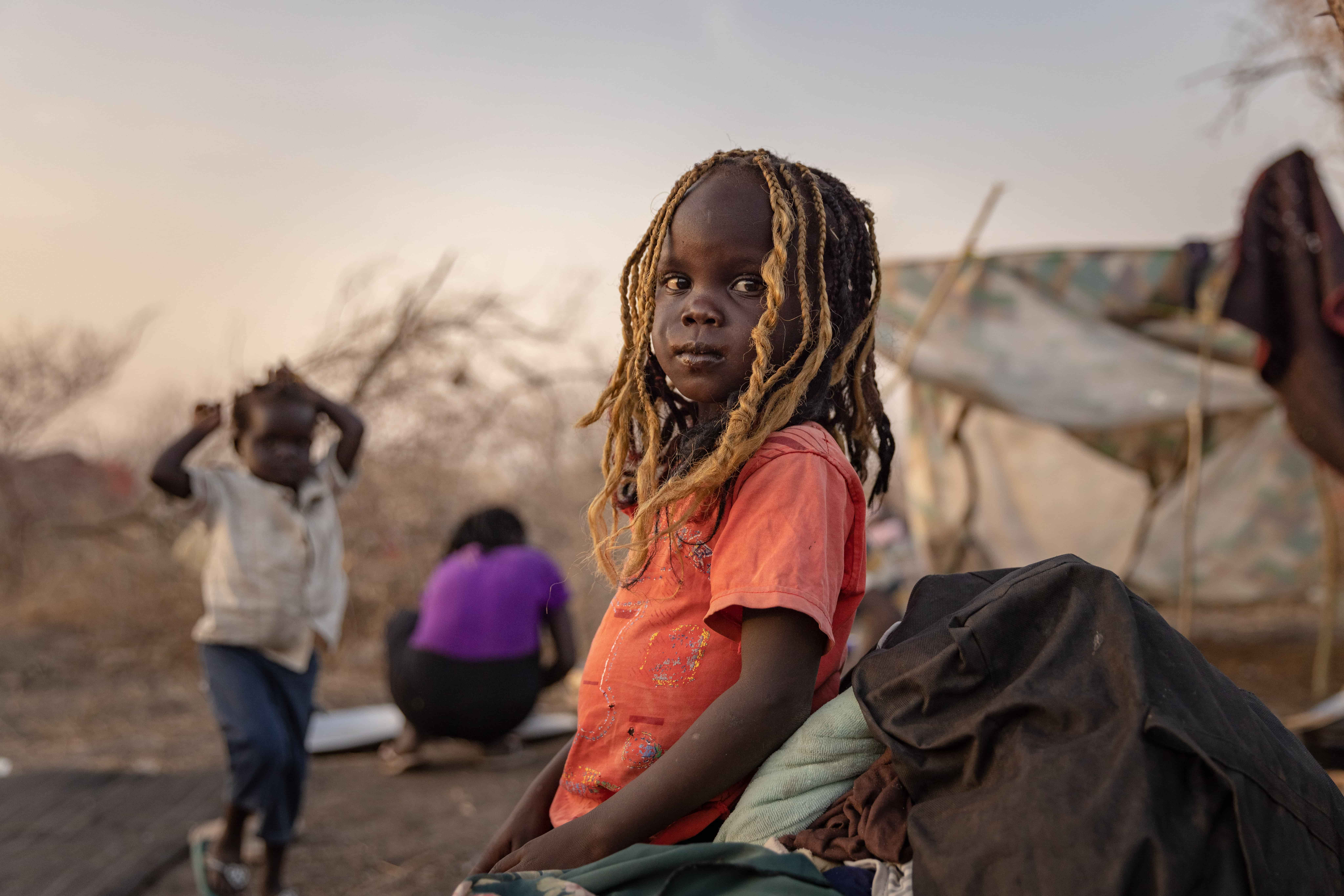 Acel, 5, stands outside his family's shelter at UNHCR's transit centre in Renk, South Sudan