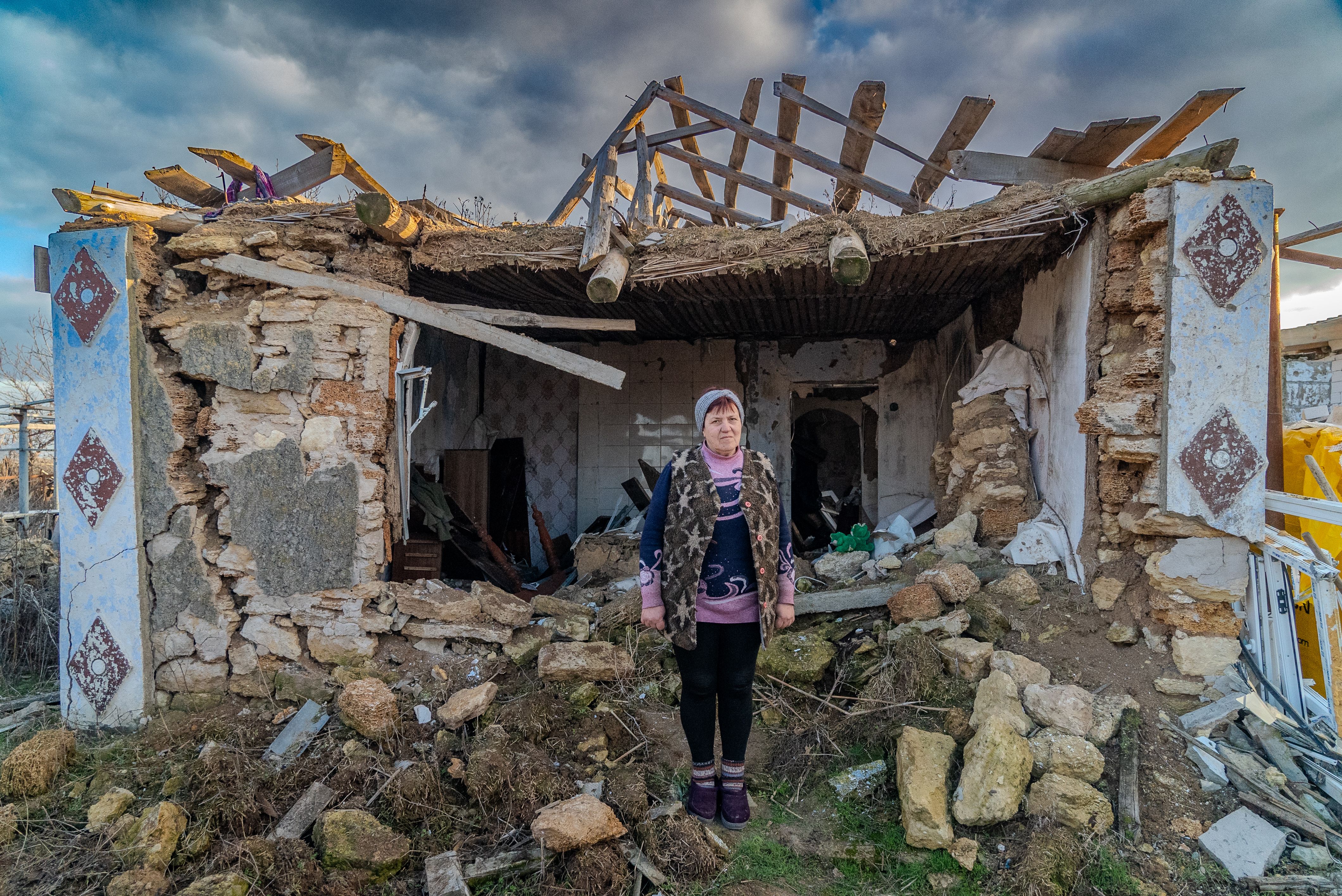 Valentyna, a 63-year-old pensioner, stands outside her destroyed home in Mykolaiv, Ukraine.